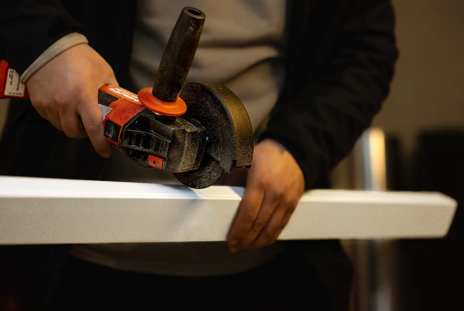 Elektrotechnik GK – ein Arbeiter, der mit einer Schleifsäge Holzstämme schneidet